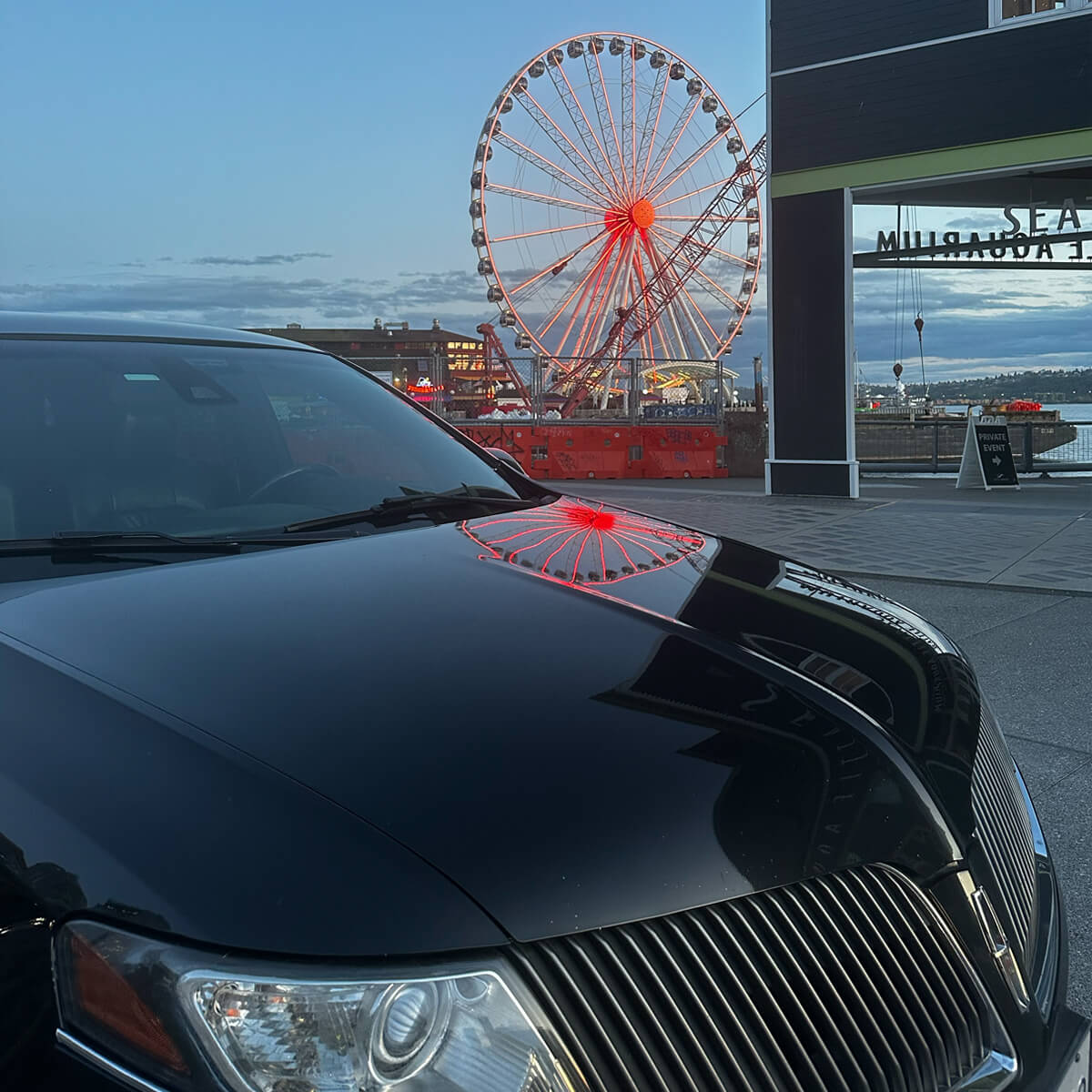 Starline's limo parked by Waterfront Park with The Seattle Great Wheel in the background